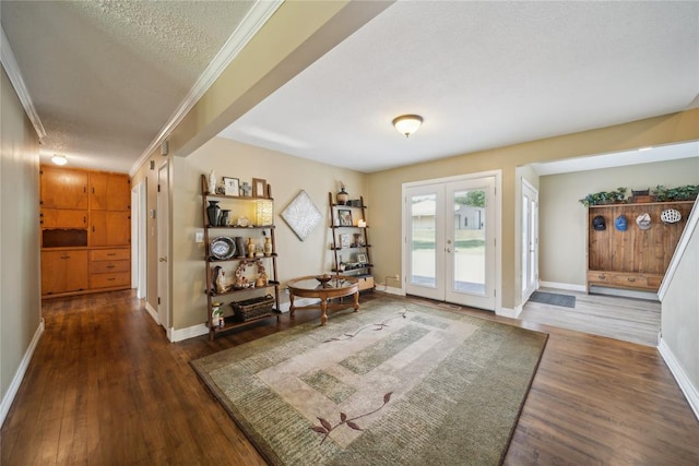 doorway to outside featuring a textured ceiling, crown molding, dark wood-type flooring, and french doors