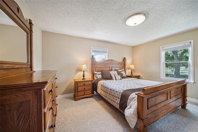 bedroom featuring a barn door, light carpet, and a textured ceiling