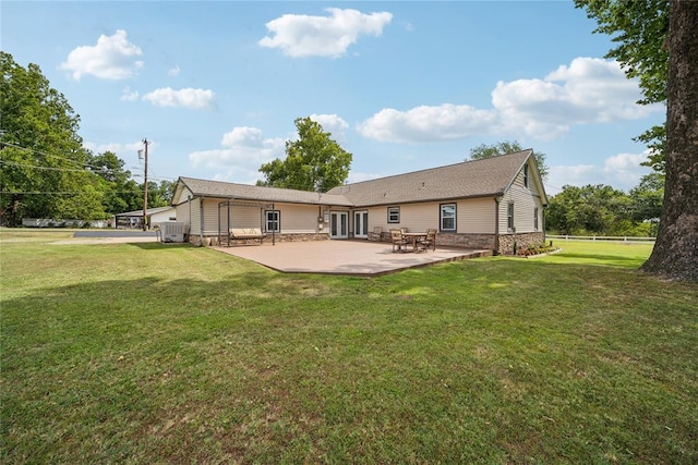 rear view of property with a yard and a patio area