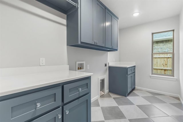 laundry room featuring electric dryer hookup, hookup for a washing machine, and cabinets