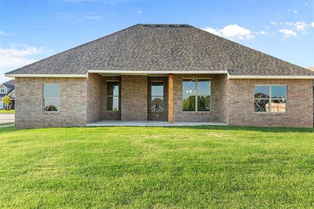 back of property with a yard and a patio