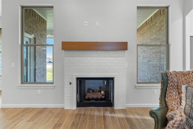 living room with wood-type flooring and a brick fireplace