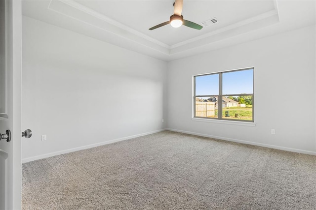 unfurnished room with carpet, ceiling fan, and a raised ceiling