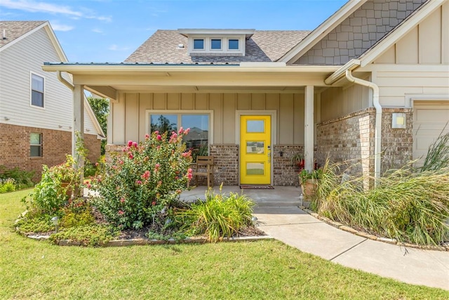 doorway to property featuring a yard and covered porch