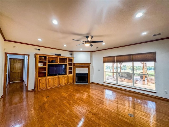 unfurnished living room with hardwood / wood-style floors, ceiling fan, and ornamental molding