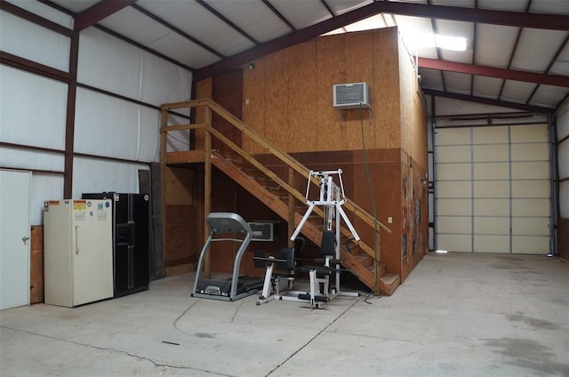 garage with a wall mounted AC and white refrigerator