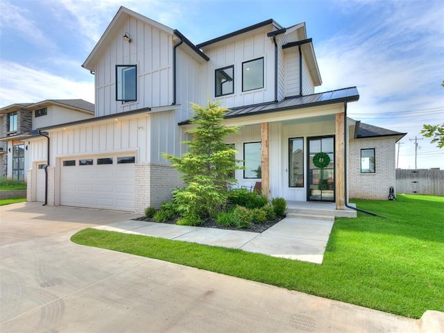 view of front of house with covered porch, a garage, and a front lawn