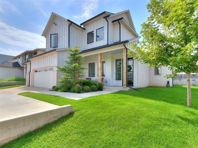 view of front of home featuring covered porch, a garage, and a front lawn