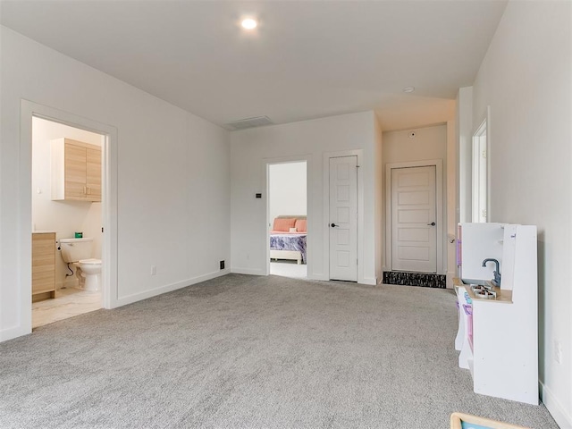 unfurnished bedroom with carpet and connected bathroom