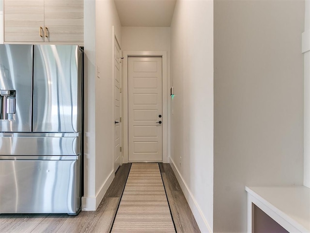 kitchen featuring hardwood / wood-style floors, stainless steel fridge with ice dispenser, and light brown cabinetry