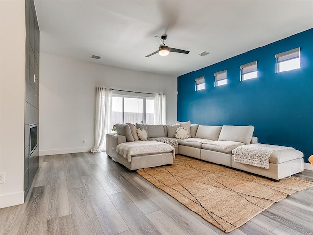 living room with light hardwood / wood-style floors and ceiling fan