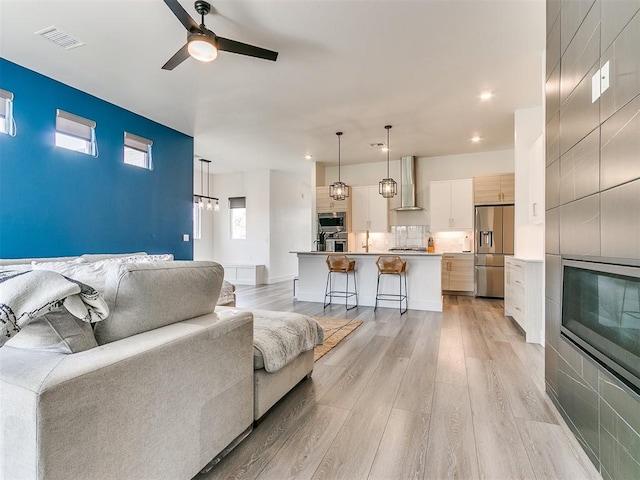 living room featuring ceiling fan and light wood-type flooring