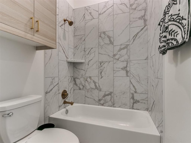 bathroom featuring tiled shower / bath combo and toilet