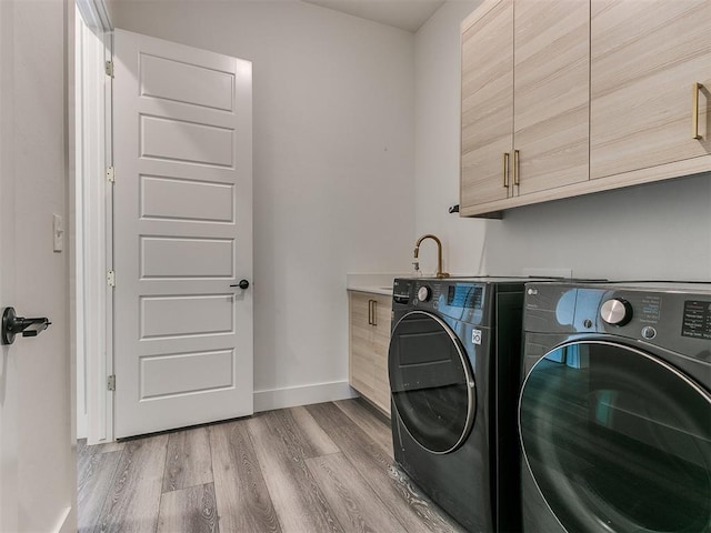 laundry area featuring light hardwood / wood-style floors, cabinets, and independent washer and dryer