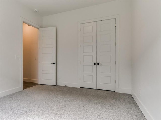 unfurnished bedroom with dark carpet and a closet