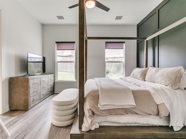 bedroom with light hardwood / wood-style flooring, multiple windows, and ceiling fan