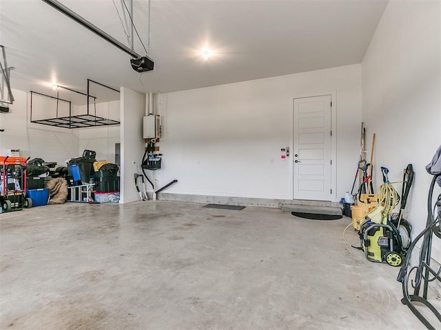 garage featuring tankless water heater and a garage door opener