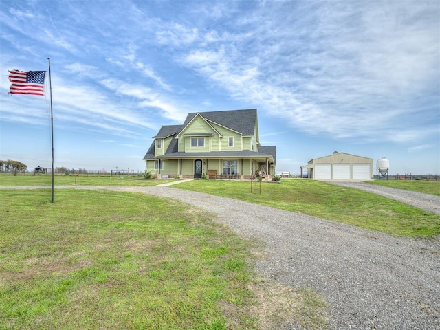 view of front of home with a front yard, a porch, an outbuilding, and a garage