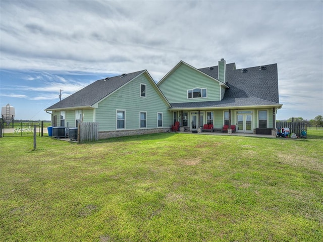 back of property with a lawn, cooling unit, and french doors