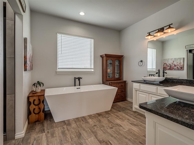 bathroom with vanity, a bath, and hardwood / wood-style flooring