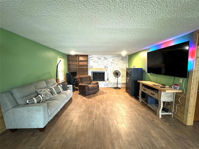 living room featuring a fireplace, wood-type flooring, and a textured ceiling