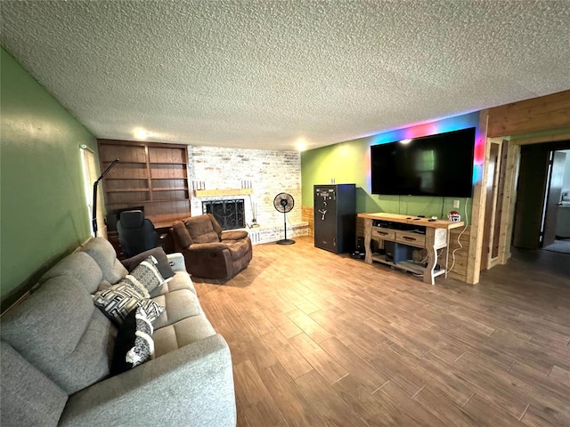 living room with a fireplace, hardwood / wood-style floors, and a textured ceiling