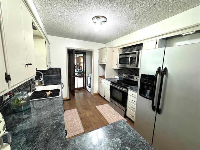 kitchen featuring sink, dark hardwood / wood-style flooring, a textured ceiling, decorative backsplash, and appliances with stainless steel finishes