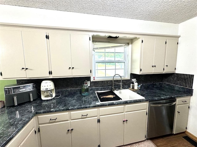 kitchen featuring dishwasher, sink, backsplash, a textured ceiling, and hardwood / wood-style flooring