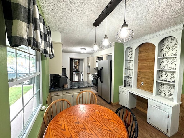 kitchen with pendant lighting, dark hardwood / wood-style flooring, stainless steel appliances, and a textured ceiling