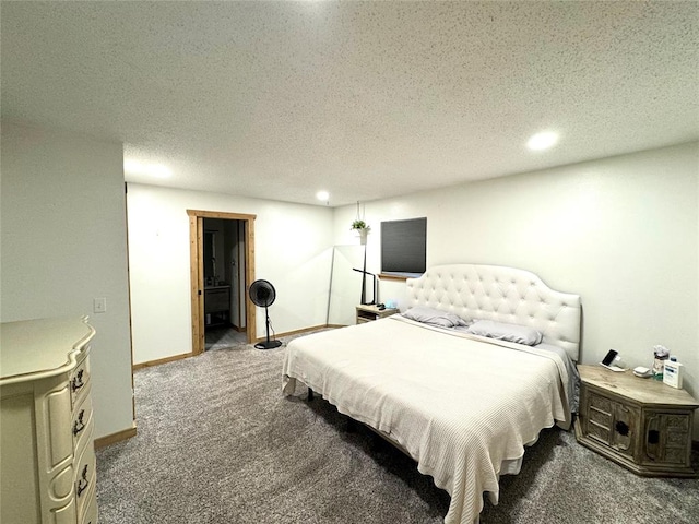 bedroom with a textured ceiling and dark colored carpet