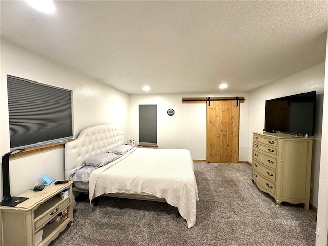 bedroom with carpet flooring, a textured ceiling, and a barn door