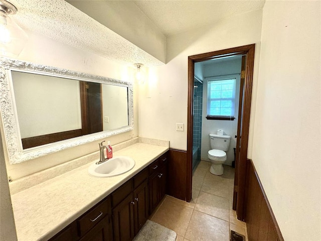 bathroom featuring tile patterned flooring, vanity, a textured ceiling, and toilet