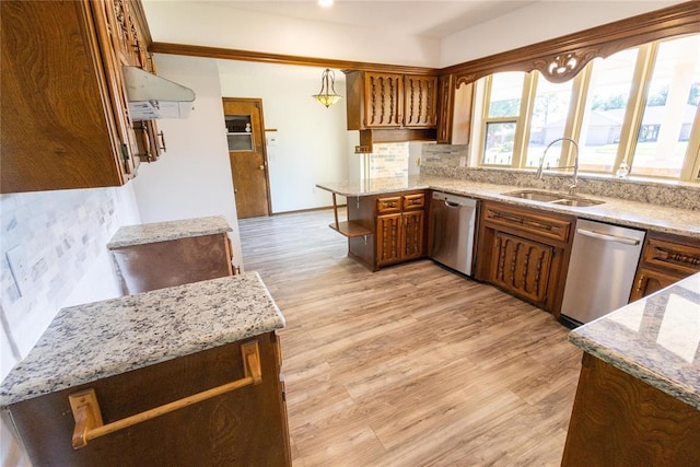 kitchen featuring dishwasher, decorative light fixtures, kitchen peninsula, and light hardwood / wood-style floors