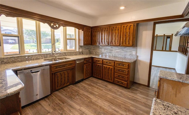 kitchen with backsplash, dishwasher, sink, and light hardwood / wood-style flooring