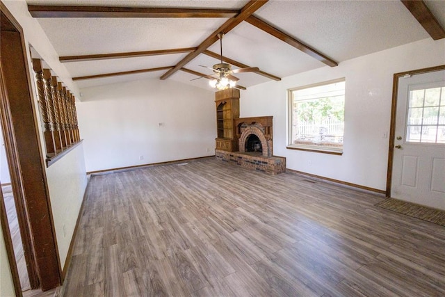 unfurnished living room with lofted ceiling with beams, hardwood / wood-style flooring, a wealth of natural light, and ceiling fan