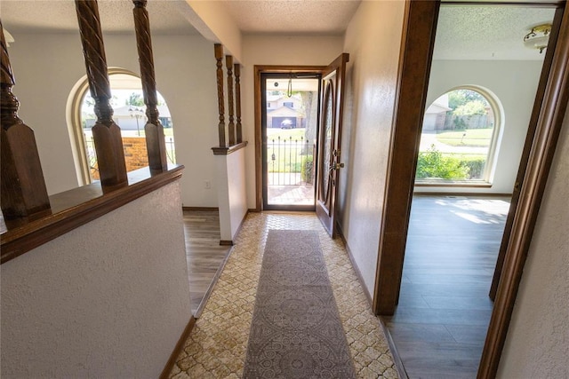 doorway with hardwood / wood-style floors and a textured ceiling