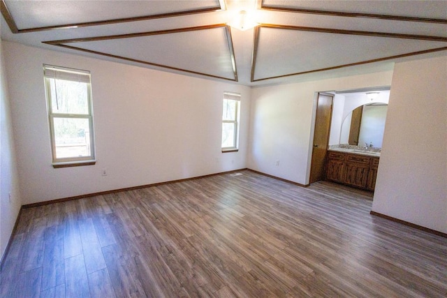 unfurnished room with hardwood / wood-style floors, plenty of natural light, and lofted ceiling