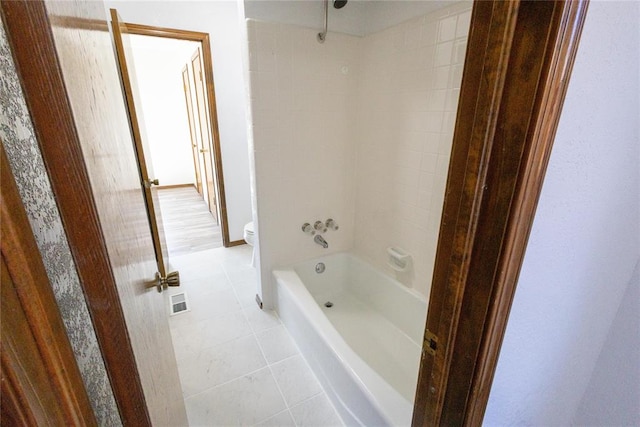 bathroom with toilet, shower / bathing tub combination, and tile patterned floors