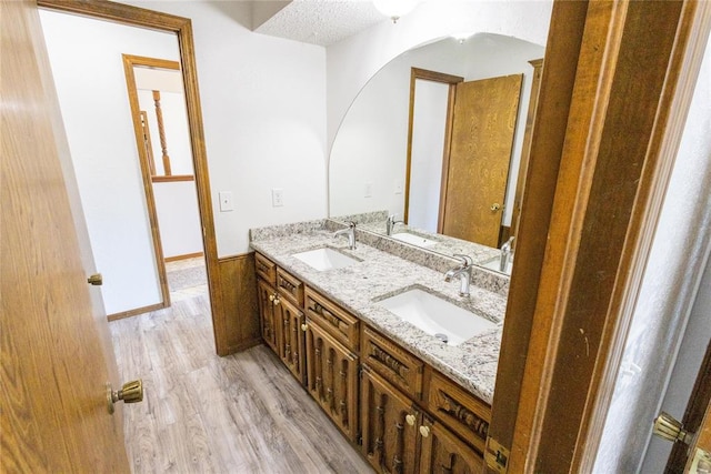 bathroom featuring hardwood / wood-style floors, vanity, and a textured ceiling