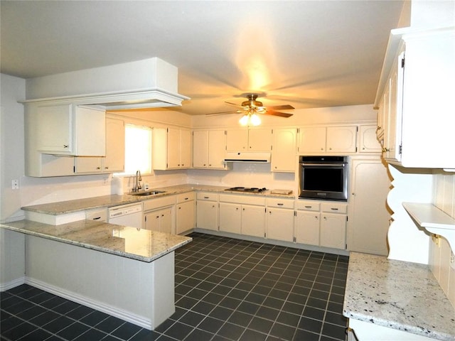 kitchen with white appliances, sink, ceiling fan, light stone countertops, and kitchen peninsula