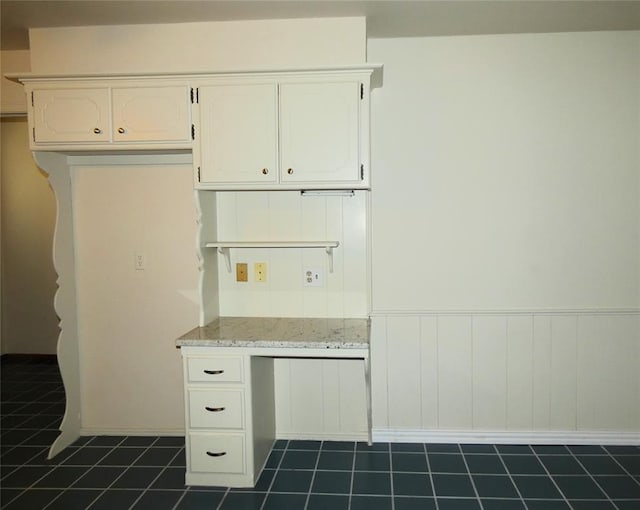 kitchen featuring white cabinets and light stone counters