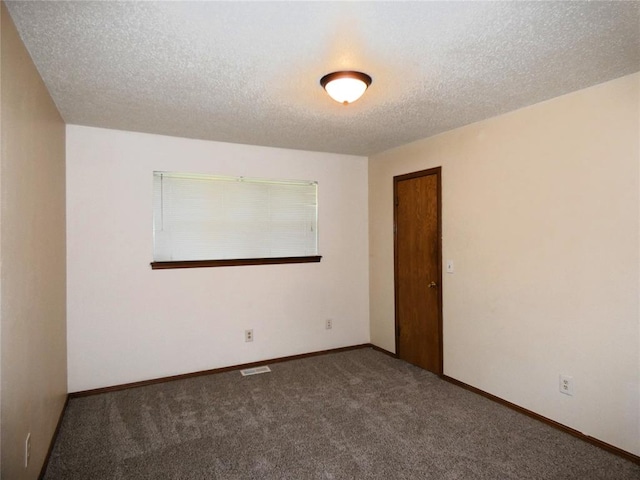 carpeted spare room with a textured ceiling