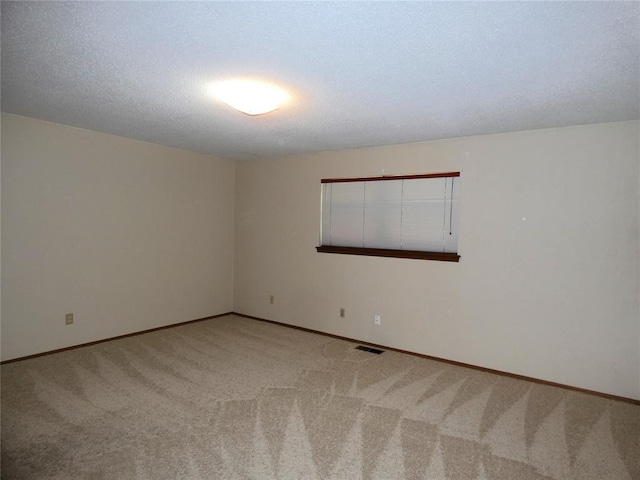 carpeted empty room featuring a textured ceiling