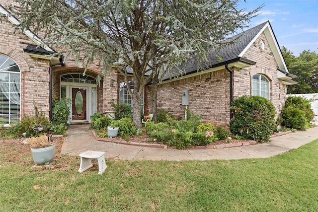 property entrance featuring a lawn