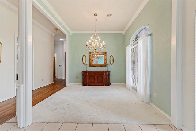 dining space with crown molding, light hardwood / wood-style flooring, and a chandelier