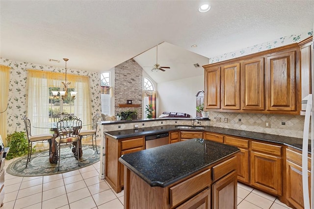 kitchen with dishwasher, hanging light fixtures, vaulted ceiling, a kitchen island, and ceiling fan with notable chandelier