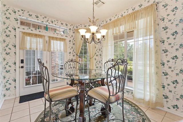 dining area with tile patterned flooring and a notable chandelier