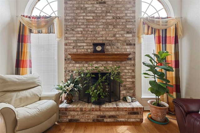 sitting room featuring hardwood / wood-style flooring and a brick fireplace