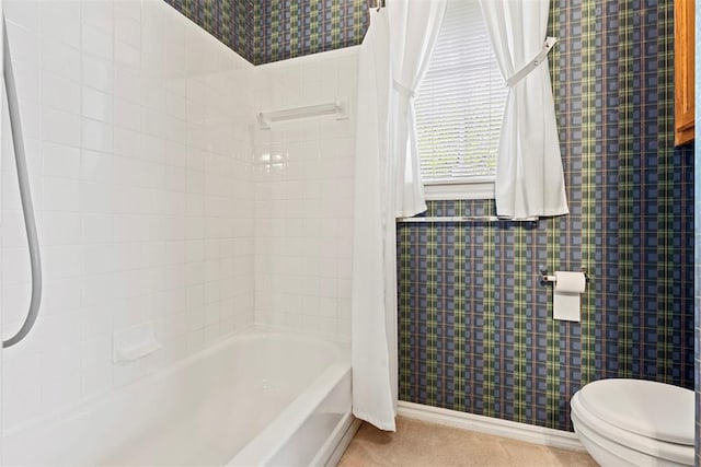 bathroom featuring shower / tub combo and toilet