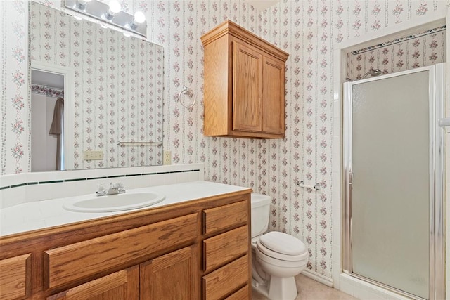 bathroom featuring vanity, toilet, and a shower with shower door